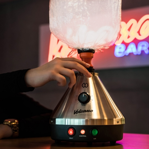 Volcano Classic Vaporizer Volcano Classic Vaporizer mit Ballon in Lounge umgebung, im Hintgergrund mit Valcano Bar Neonlichreklame