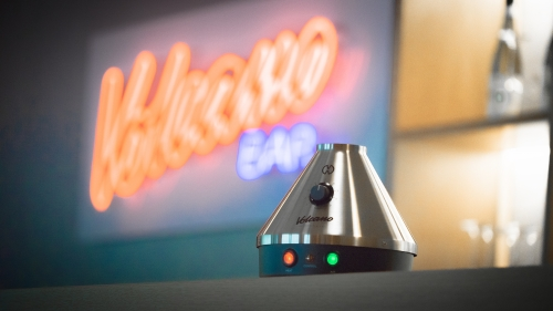 Volcano Classic Vaporizer Volcano Classic in Lounge umgebung im Hintergrund mit Volcano Neonlichtreklame
